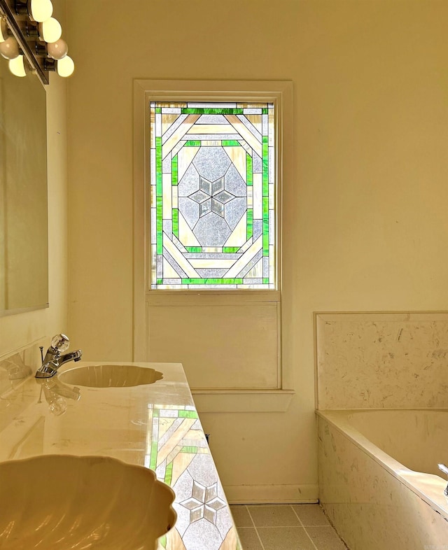 bathroom with tile patterned floors, tiled bath, and vanity