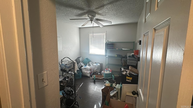 interior space with ceiling fan, dark hardwood / wood-style floors, and a textured ceiling