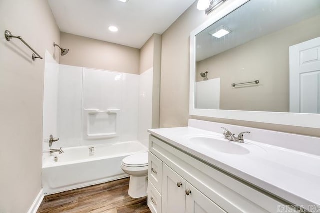 full bathroom with hardwood / wood-style floors, vanity, toilet, and shower / tub combination