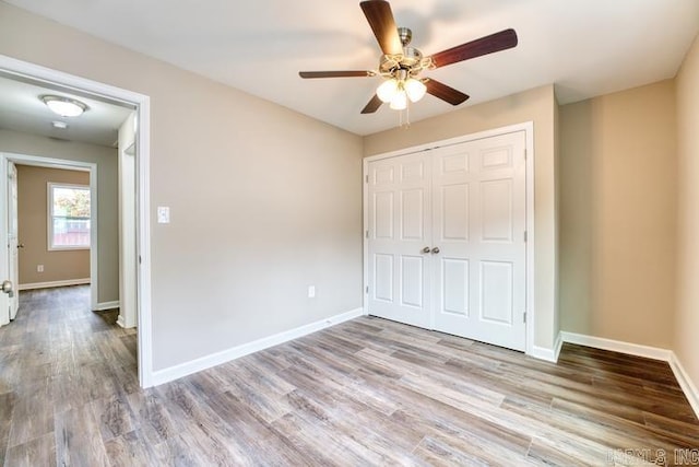 unfurnished bedroom with ceiling fan, a closet, and light hardwood / wood-style floors