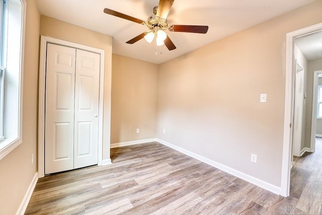 unfurnished bedroom featuring light wood-type flooring, a closet, and ceiling fan