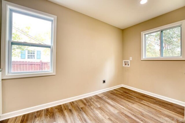 empty room with wood-type flooring and a healthy amount of sunlight