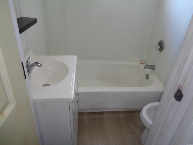 bathroom with toilet, wood-type flooring, and vanity