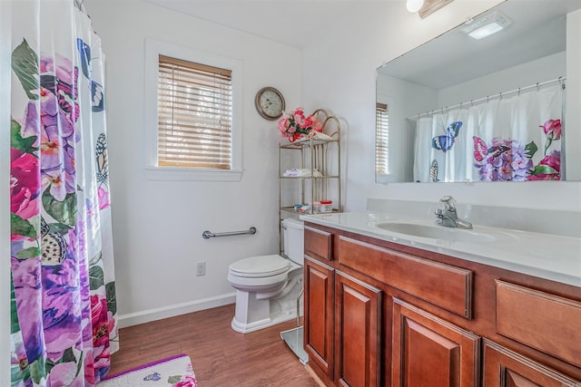 bathroom with wood-type flooring, vanity, toilet, and walk in shower