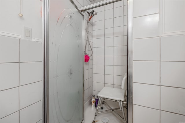 bathroom featuring a tile shower and tile walls