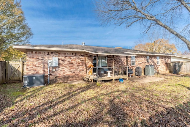 rear view of house with a wooden deck, a yard, and cooling unit