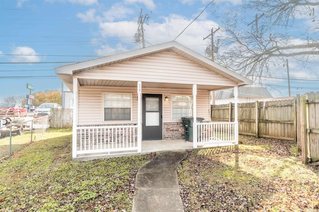 bungalow-style house featuring a front lawn and covered porch