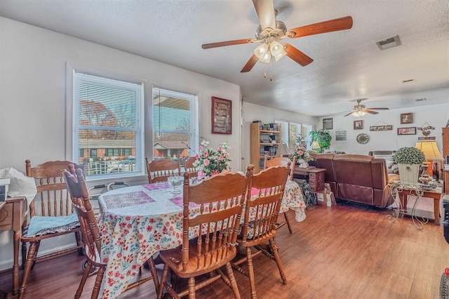 dining room featuring ceiling fan, wood-type flooring, and a textured ceiling