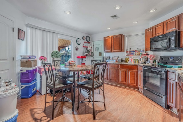 kitchen with light hardwood / wood-style floors and black appliances