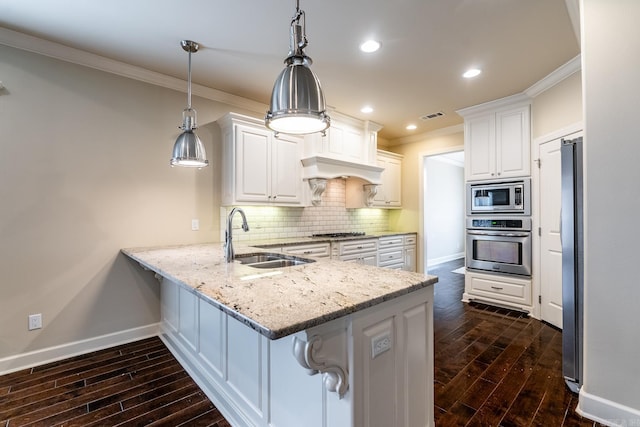 kitchen with white cabinetry, sink, stainless steel appliances, dark hardwood / wood-style flooring, and pendant lighting