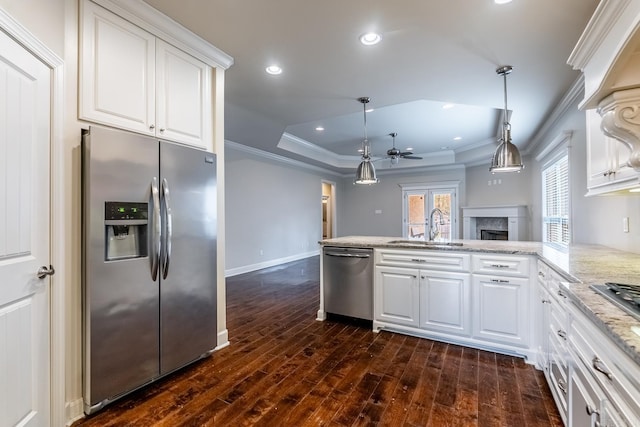 kitchen featuring kitchen peninsula, stainless steel appliances, white cabinetry, and sink