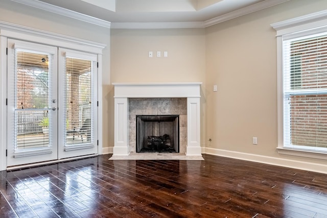 unfurnished living room featuring a premium fireplace, french doors, dark wood-type flooring, and ornamental molding