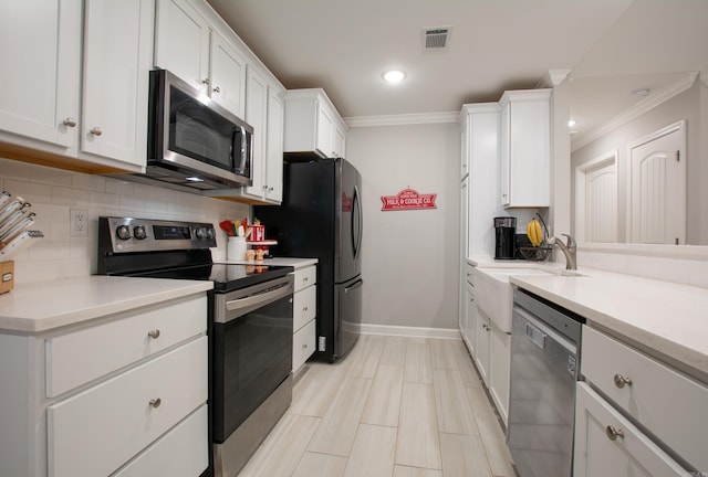 kitchen with backsplash, white cabinetry, sink, and stainless steel appliances