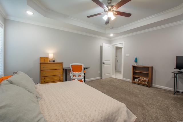 carpeted bedroom featuring ceiling fan, ornamental molding, and a tray ceiling