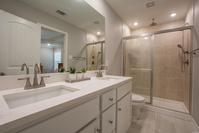 bathroom featuring vanity, toilet, and an enclosed shower