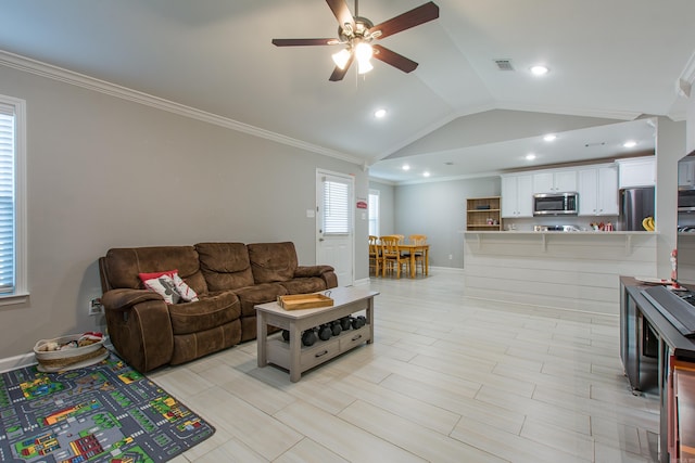 living room featuring ceiling fan, ornamental molding, and vaulted ceiling