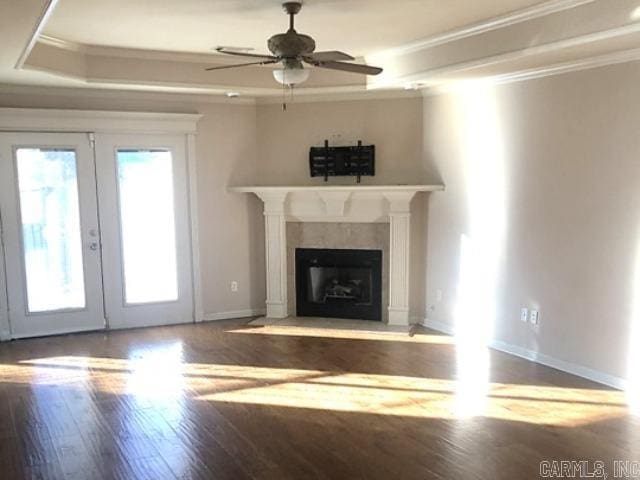 unfurnished living room featuring hardwood / wood-style flooring, ceiling fan, ornamental molding, and french doors