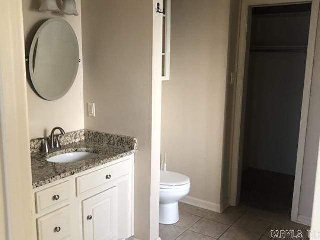 bathroom featuring tile patterned flooring, vanity, and toilet