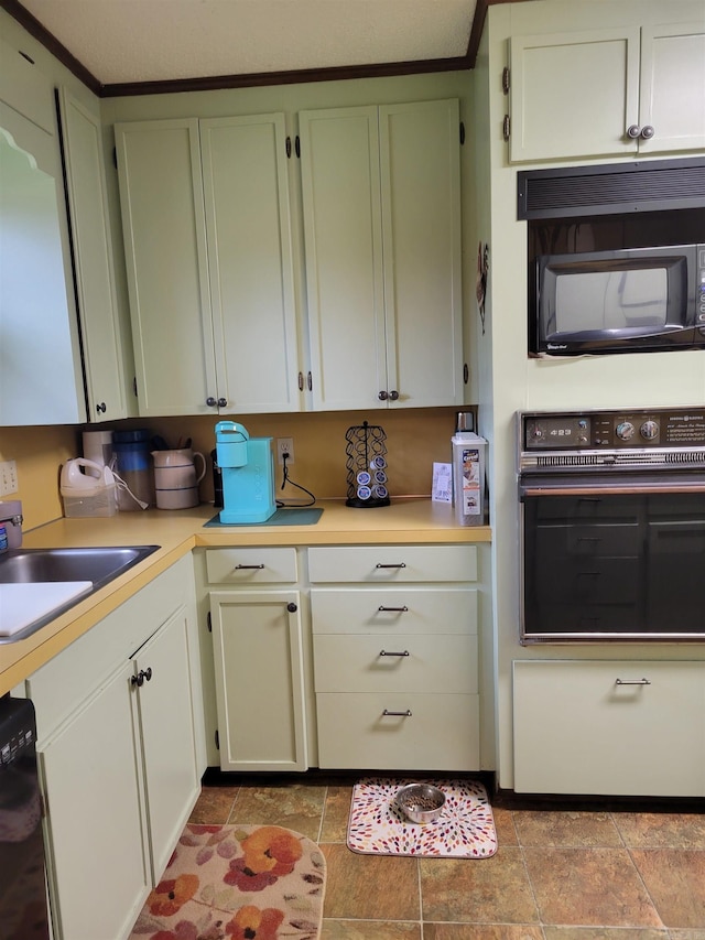 kitchen with sink, black appliances, a textured ceiling, and ornamental molding