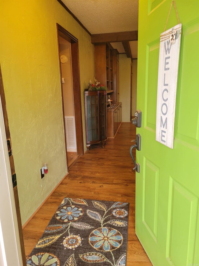 corridor with hardwood / wood-style flooring and a textured ceiling