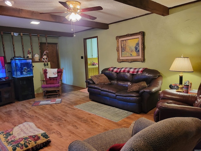 living room with hardwood / wood-style floors, a textured ceiling, ceiling fan, and beam ceiling