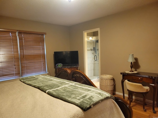 bedroom with hardwood / wood-style flooring and ensuite bathroom