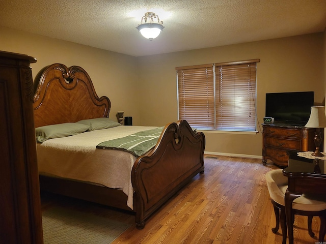 bedroom featuring light hardwood / wood-style flooring and a textured ceiling