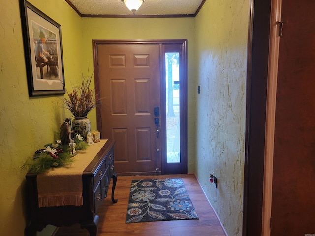 entryway with hardwood / wood-style floors, a textured ceiling, and crown molding