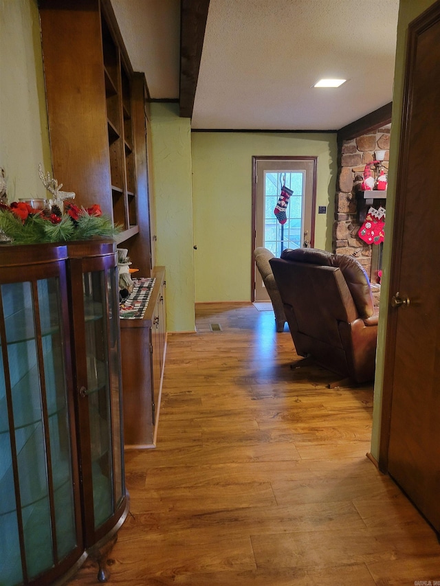 hallway featuring a textured ceiling and light hardwood / wood-style flooring