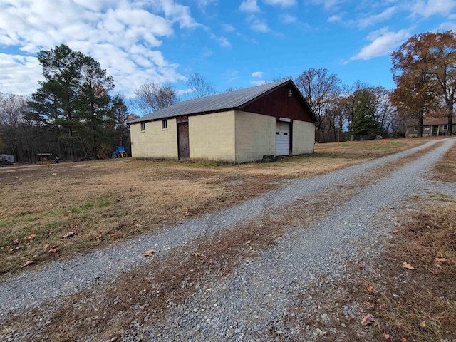 exterior space with a garage and an outbuilding