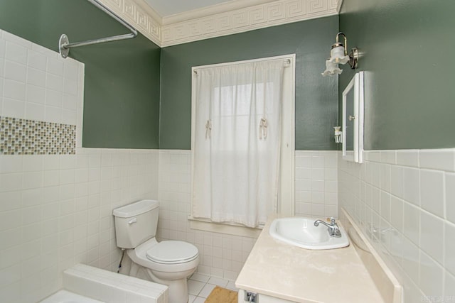 bathroom with tile patterned flooring, vanity, toilet, and tile walls