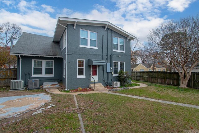 back of house featuring a yard and central AC