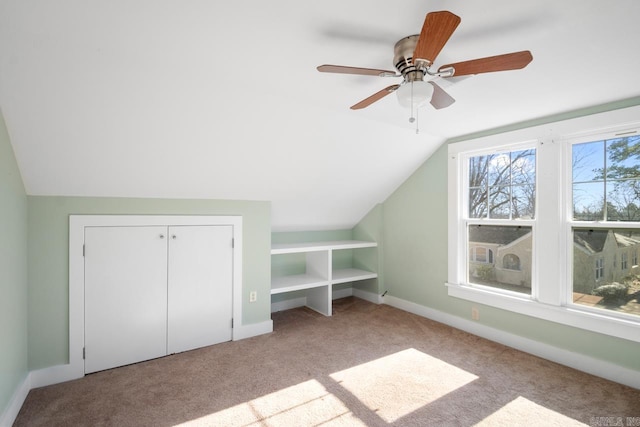 bonus room featuring ceiling fan, light carpet, and vaulted ceiling