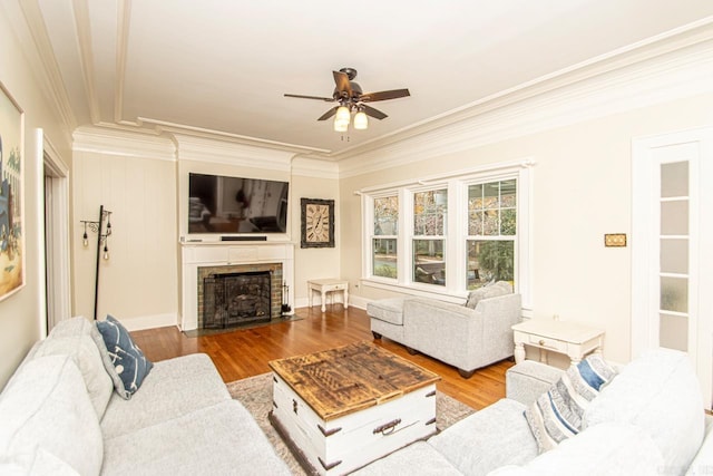 living room with hardwood / wood-style flooring, ceiling fan, and crown molding