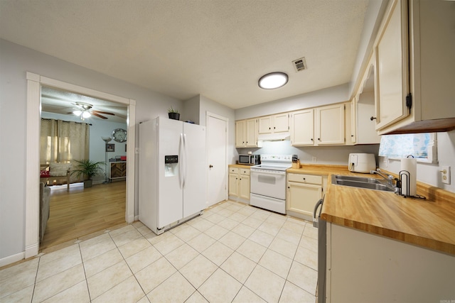 kitchen featuring a textured ceiling, white appliances, ceiling fan, sink, and light hardwood / wood-style flooring