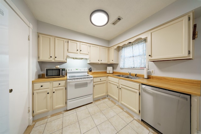 kitchen featuring cream cabinetry, light tile patterned floors, sink, and appliances with stainless steel finishes