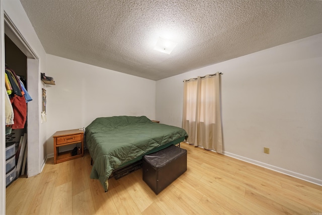 bedroom with hardwood / wood-style floors and a textured ceiling