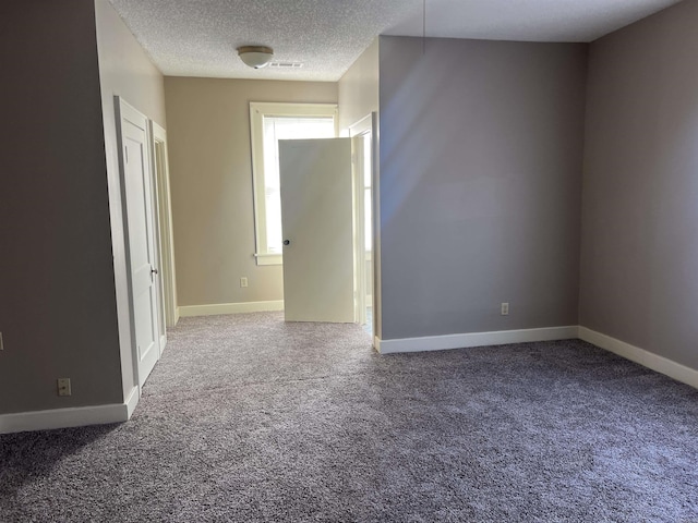 spare room featuring carpet flooring and a textured ceiling