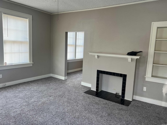 unfurnished living room with dark colored carpet, ornamental molding, a textured ceiling, and a tile fireplace