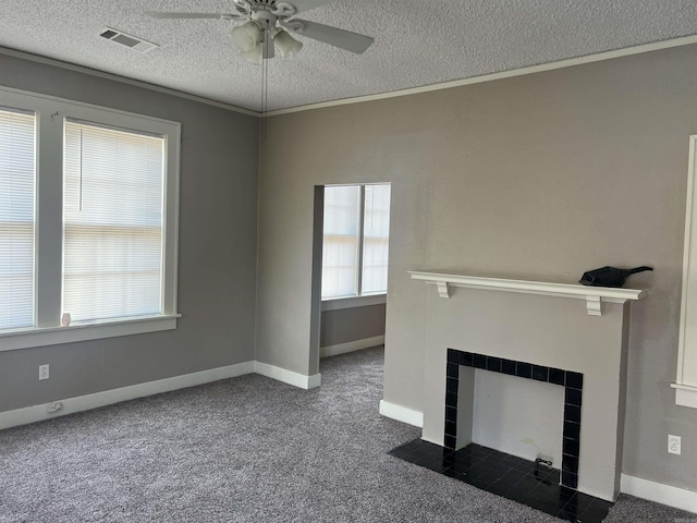 unfurnished living room with dark carpet, a healthy amount of sunlight, and a textured ceiling