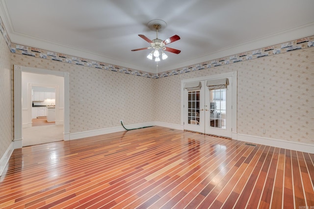 spare room featuring french doors, hardwood / wood-style flooring, ceiling fan, and crown molding