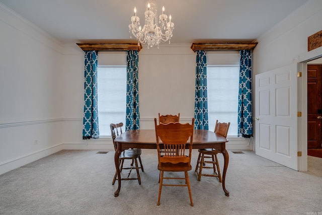 carpeted dining space with ornamental molding and a chandelier