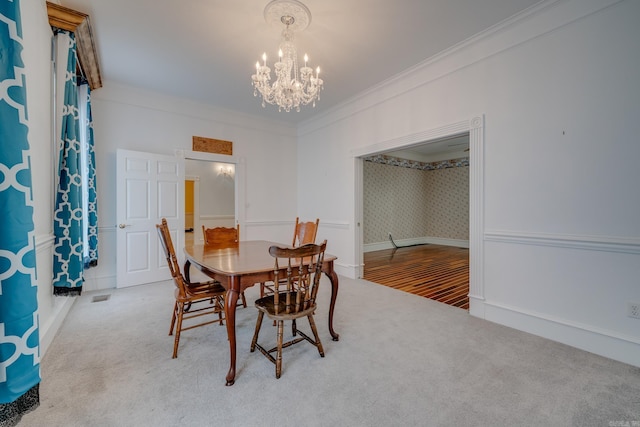 dining room featuring carpet floors, crown molding, and a notable chandelier