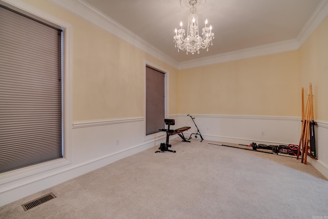 workout area featuring carpet floors, a notable chandelier, and ornamental molding