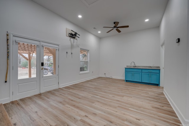 interior space with ceiling fan, sink, and light wood-type flooring