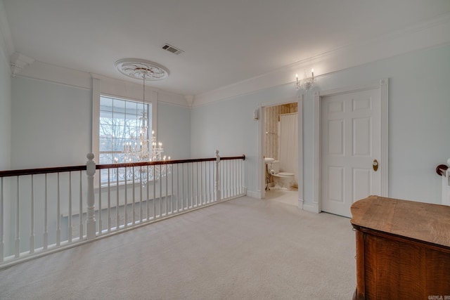 empty room with ornamental molding, light colored carpet, and an inviting chandelier