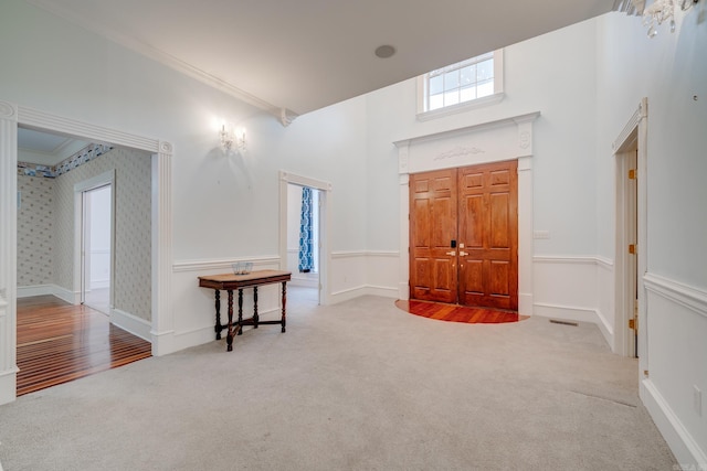 carpeted entryway with ornamental molding