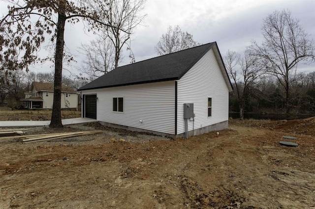 view of side of property with an outdoor structure and a garage