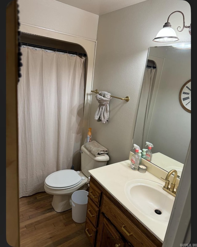 bathroom featuring toilet, vanity, and hardwood / wood-style flooring