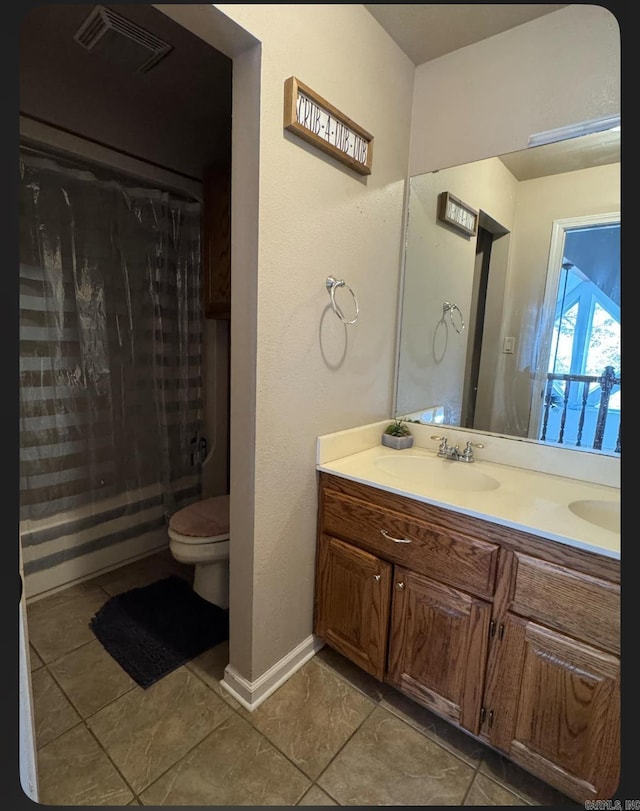 bathroom featuring tile patterned flooring, vanity, and toilet